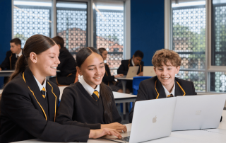 A photo of three students happily learning in a classroom at Corpus Christi Maroubra and on their way to NAPLAN 2026 results success